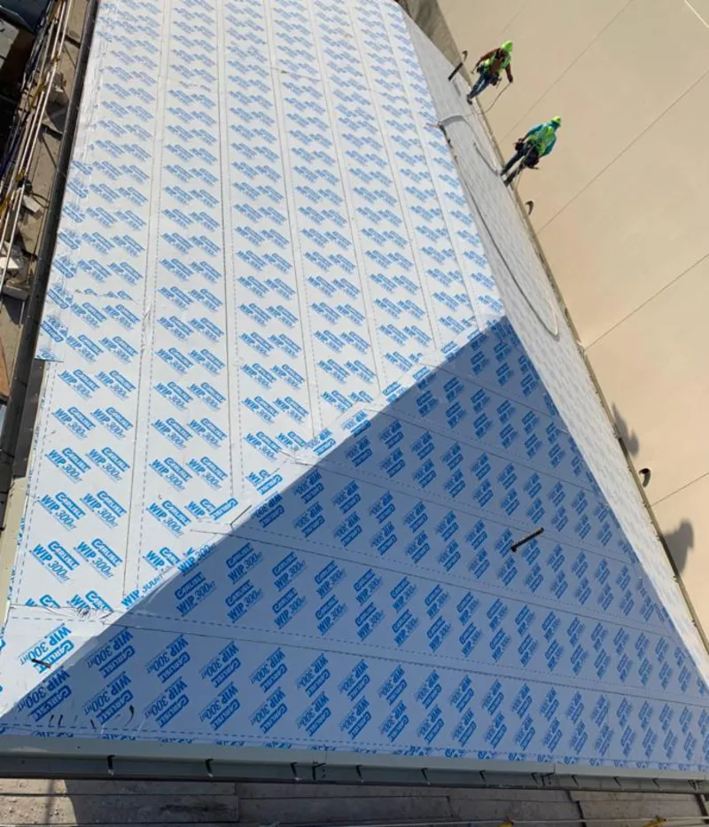 Professional roofers installing underlayment on a metal roof in Tarrytown